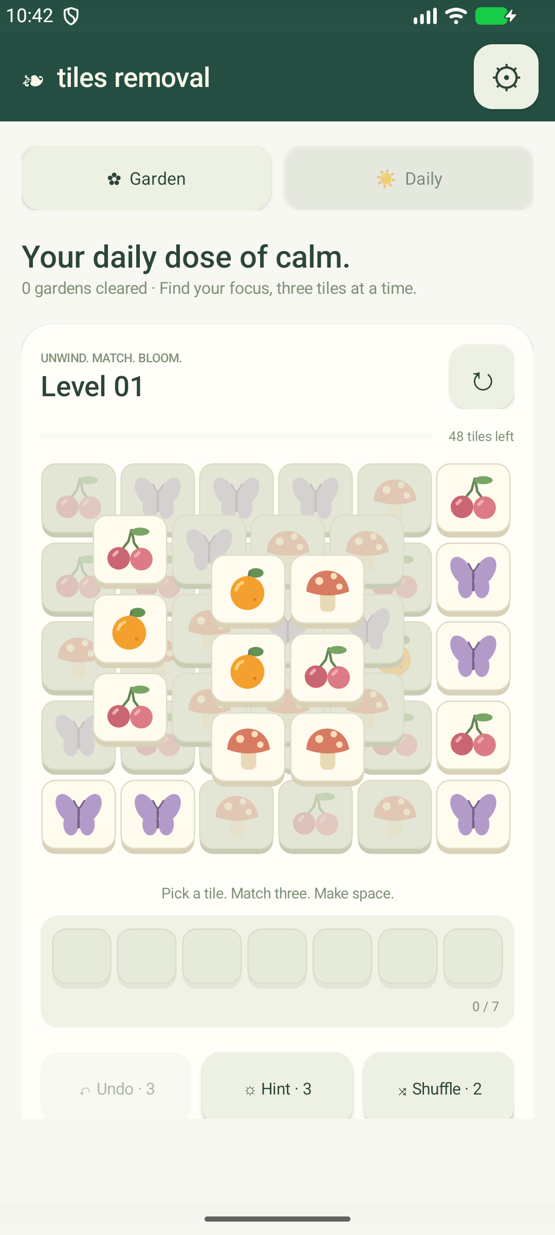 Android gameplay: a layered garden of fruit, butterfly and mushroom tiles above a seven-slot tray, with Undo, Hint and Shuffle controls